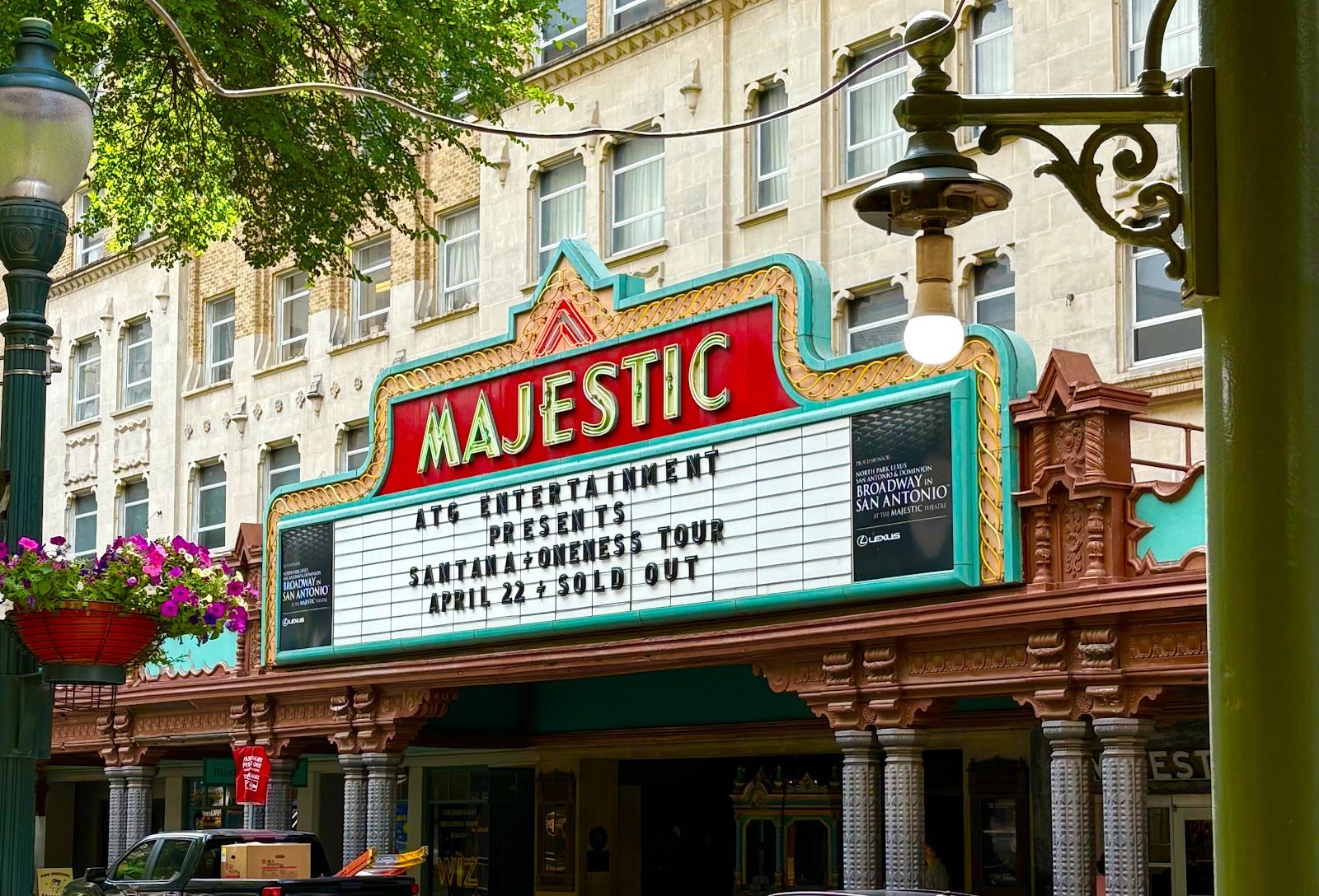 The Majestic Theatre's red and turquoise marquee with green neon MAJESTIC letters above an ornate cast-iron canopy on Houston Street, San Antonio