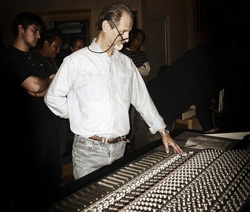Eddie Kramer, gray-haired with glasses on a cord, leaning over a large mixing console while students watch in a dim studio