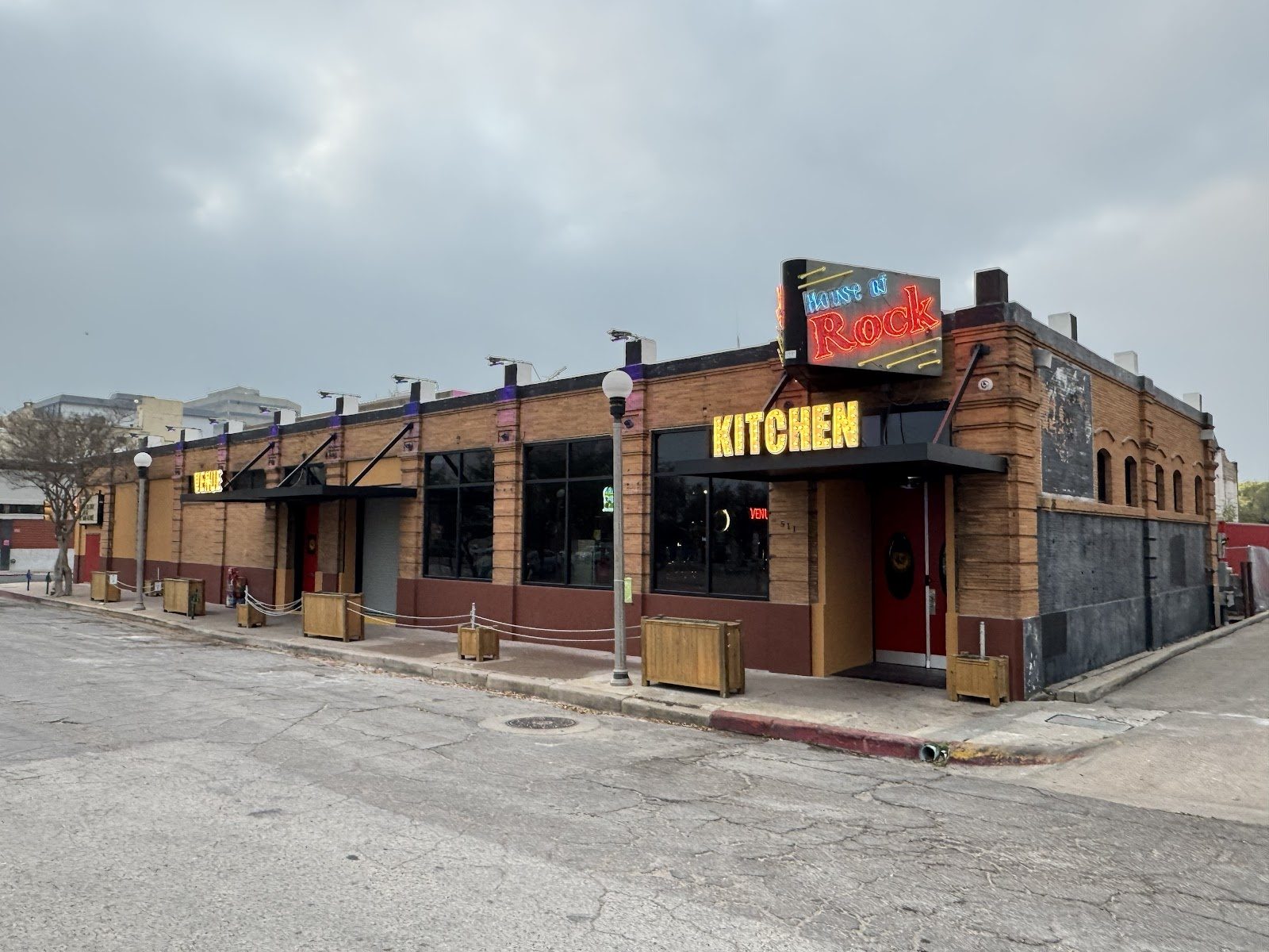 The brick corner exterior of House of Rock in downtown Corpus Christi with neon signs reading House of Rock and Kitchen