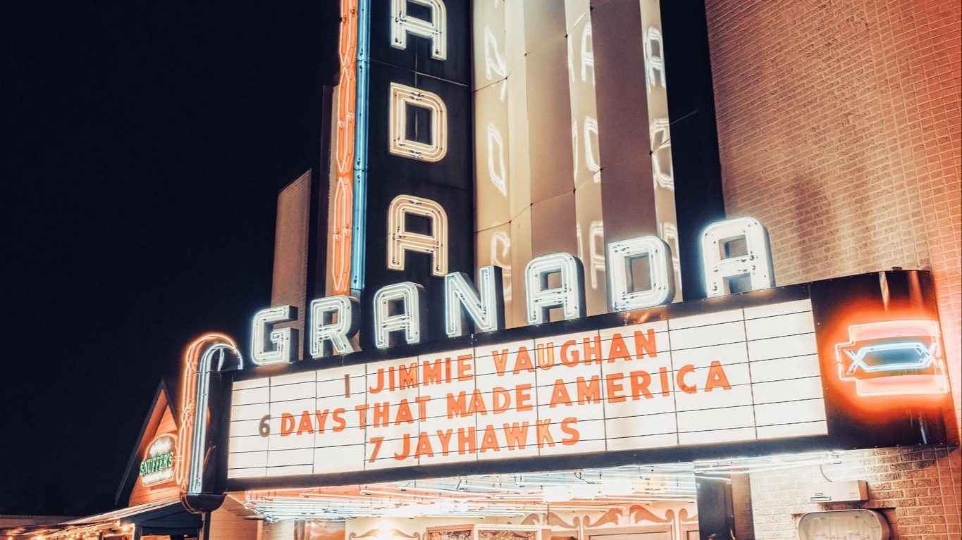 The Granada Theater's lit neon vertical sign and marquee at night on Greenville Avenue