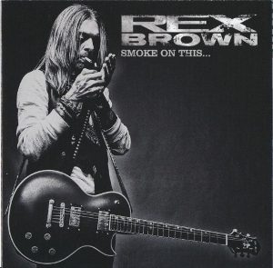 Smoke on This album cover: a black-and-white photo of Rex Brown with long hair, cupping his hands to his mouth, with a single-cutaway electric guitar slung across him