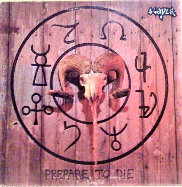 Prepare to Die cover: a ram's skull inside a circle of black occult and planetary symbols painted on weathered wooden planks, with a small Slayer logo top right and the title stenciled along the bottom