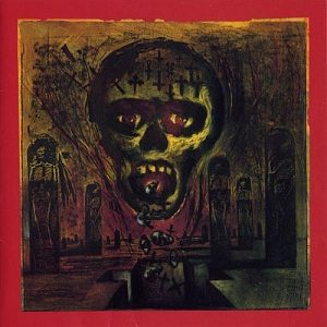 Album cover of Seasons in the Abyss: a green, rotting skull face with glowing red eyes rising from a dark landscape of tombstones, framed by a red border