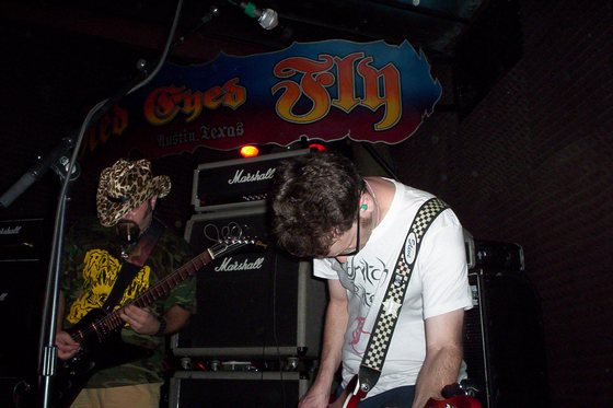 Bent over the guitar.